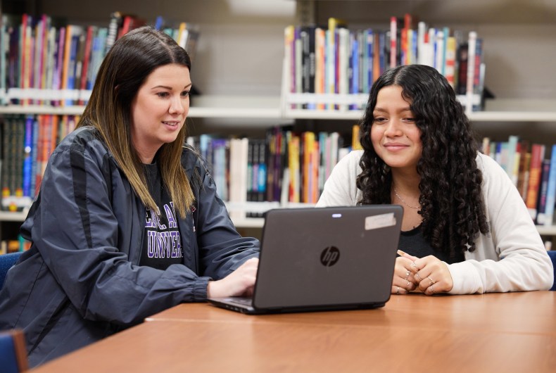 Teacher and student looking at laptop