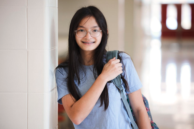 Girl leaning with glasses and backpack