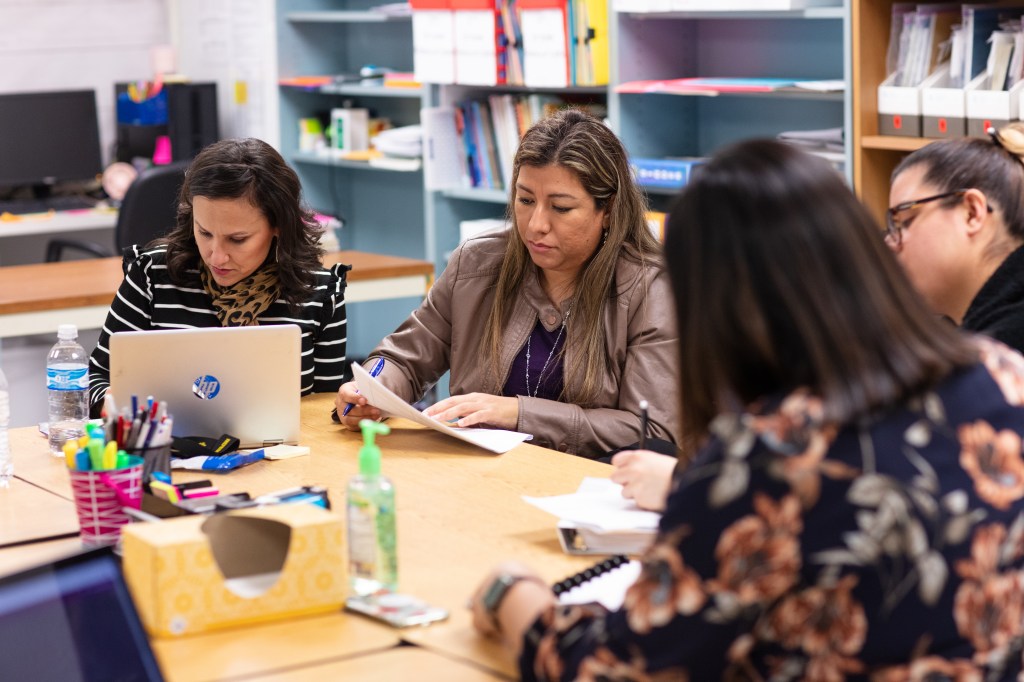 Four female teachers at a table working together.